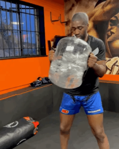 Man lifting the HELIOS water weight bag during a gym workout